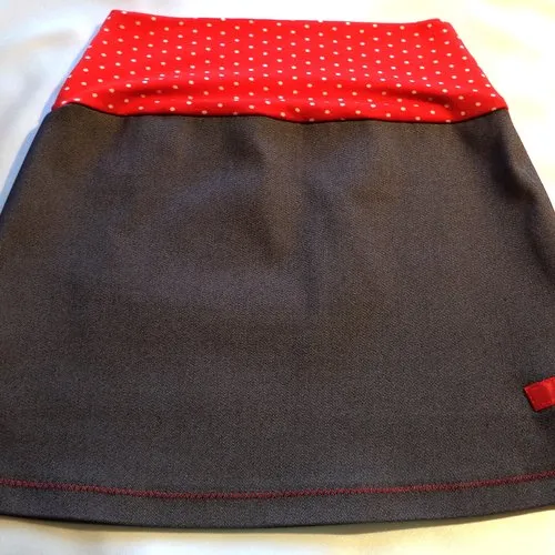 Girls' light stretch denim skirt with wide red and white polka dot belt and appliqués.