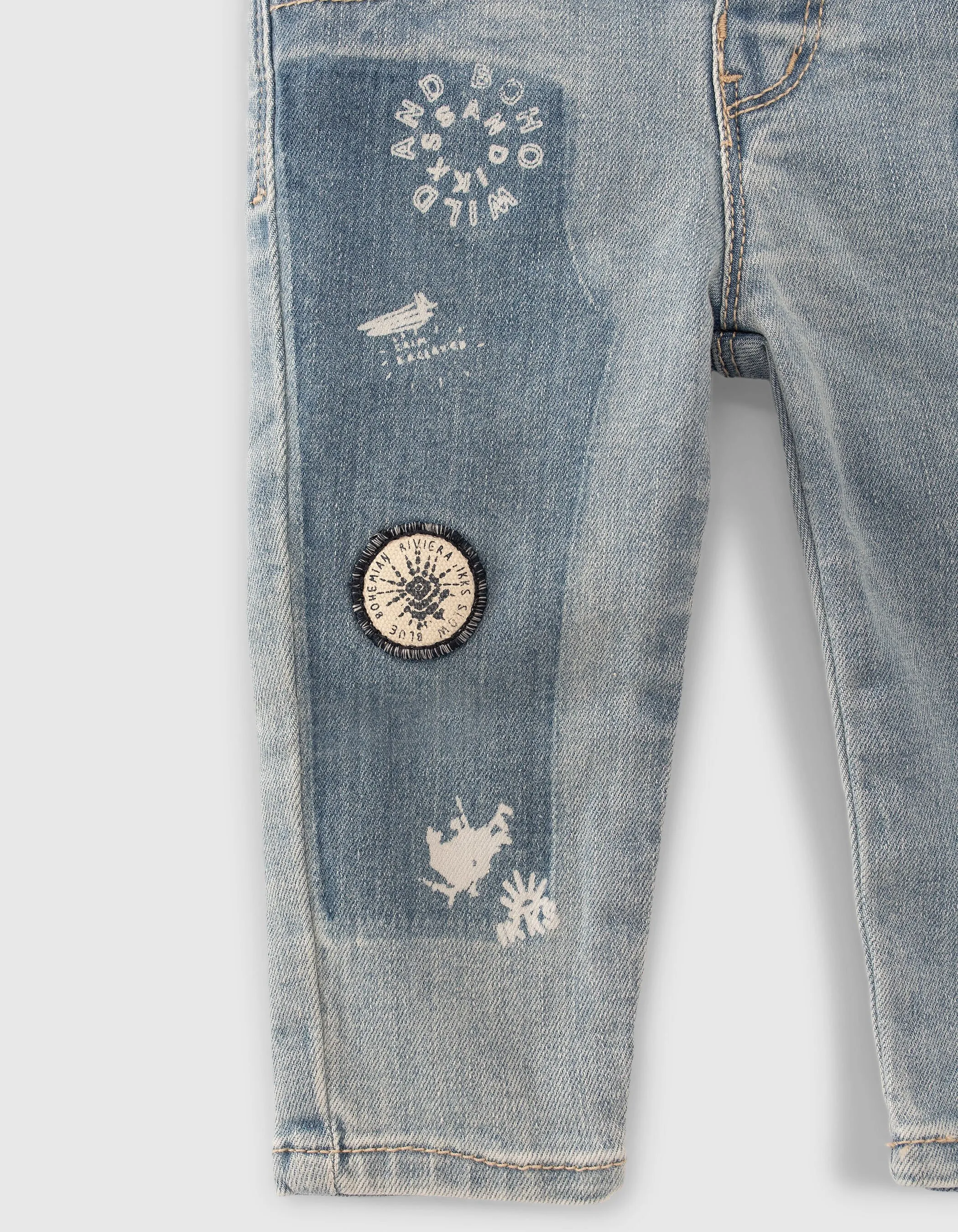 Blue jeans with print and baby boy badge.