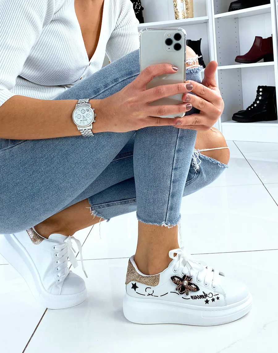 White platform sneakers with embroidered details.